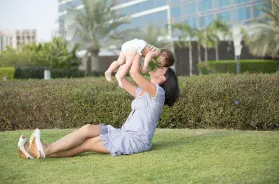 Estimados padres nuevos, un sueño de calidad es posible con un purificador de aire : Mujer jugando con bebé afuera en aire limpio