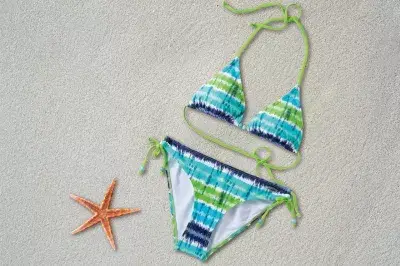 Cómo pedirle a tu novia que modele un bikini : Bikini tendido en la arena cerca de una estrella de mar